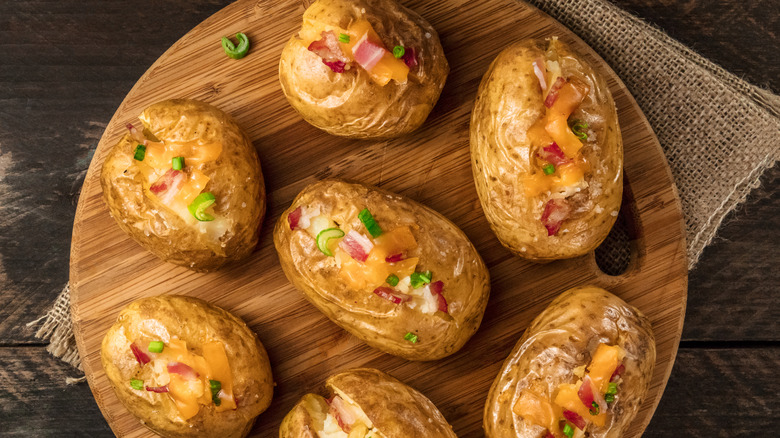 overhead photo of baked potatoes on wooden plate