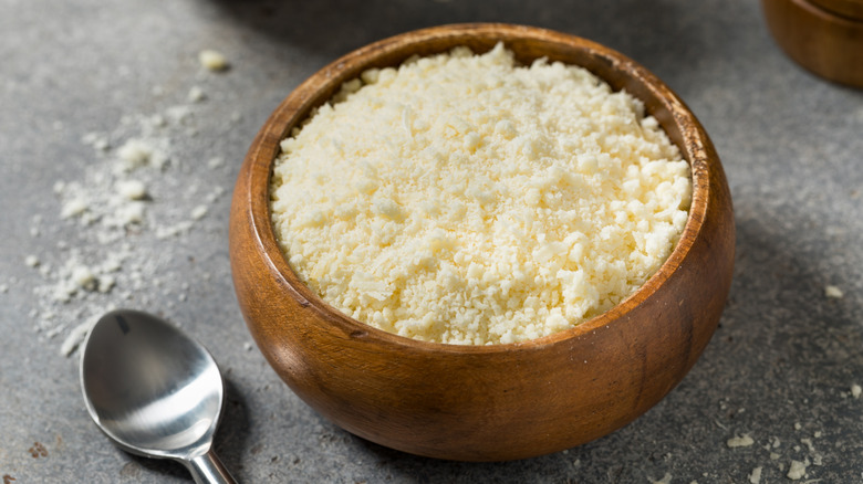 Grated Parmesan cheese in a wooden bowl.