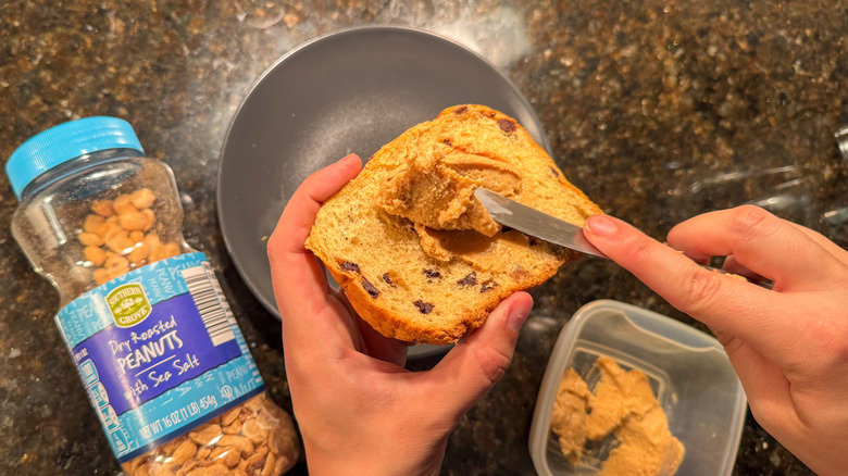 Person spreading peanut butter on toast