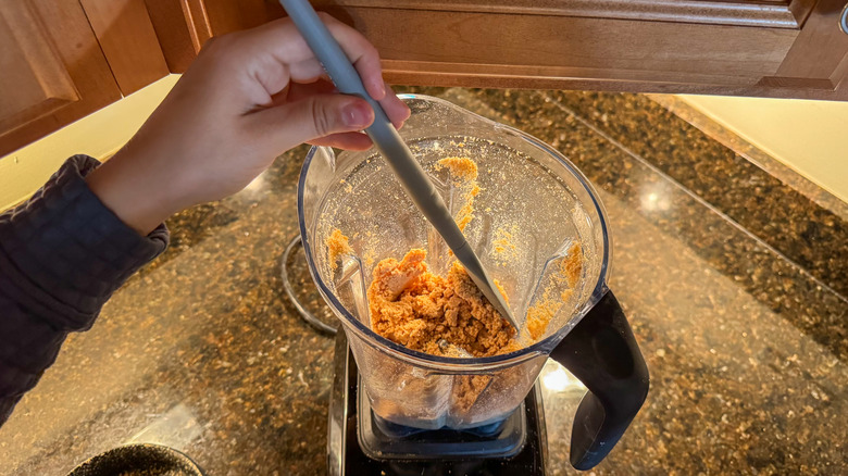Person scraping down sides of Vitamix blender