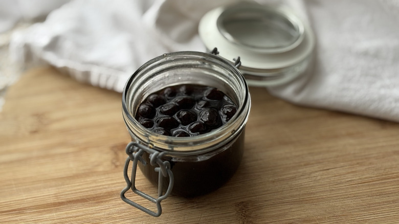 small glass jar with sealed lid full of cooked boba
