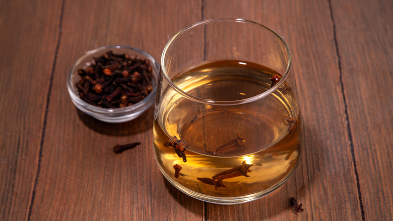 infused clove water tea in a clear glass