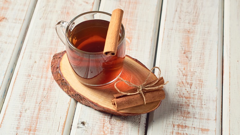 cinnamon tea in a transparent cup with a cinnamon stick garnish