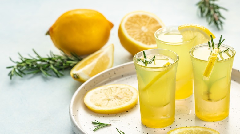 three lemon shots with rosemary garnish
