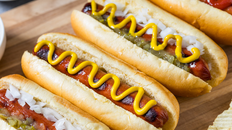 traditional hot dogs on a wooden cutting board