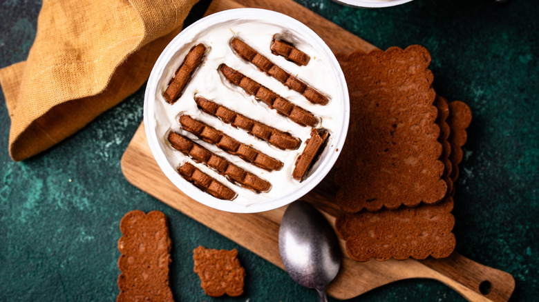 Viral Japanese cheesecake made in greek yogurt container on wood cutting board next to spoon.