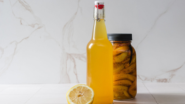 A bottle of vodka next to a group of citrus fruits