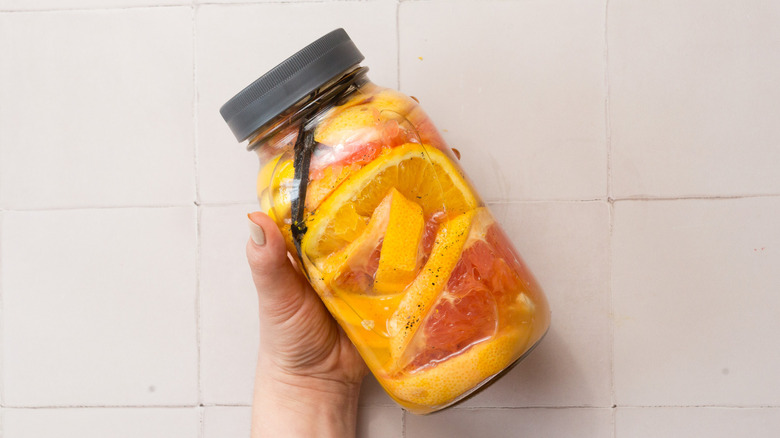 Hand holding jar with infused vodka