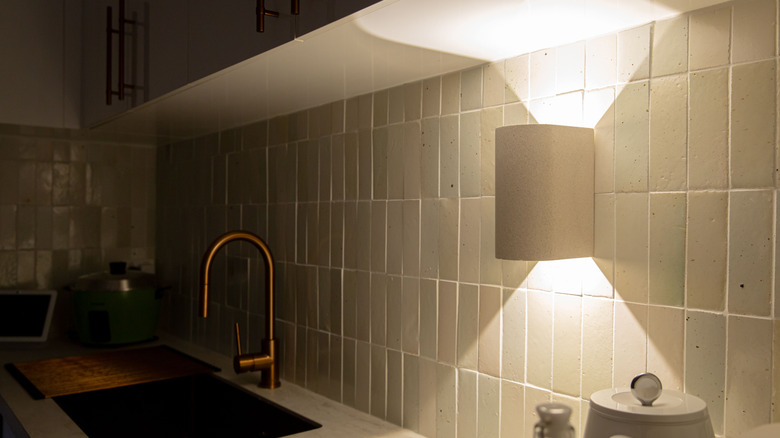 Under-cabinet sconce light next to kitchen sink