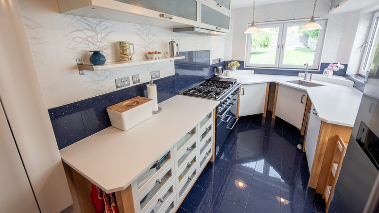 C-shaped kitchen with wood accents, shiny dark blue floors