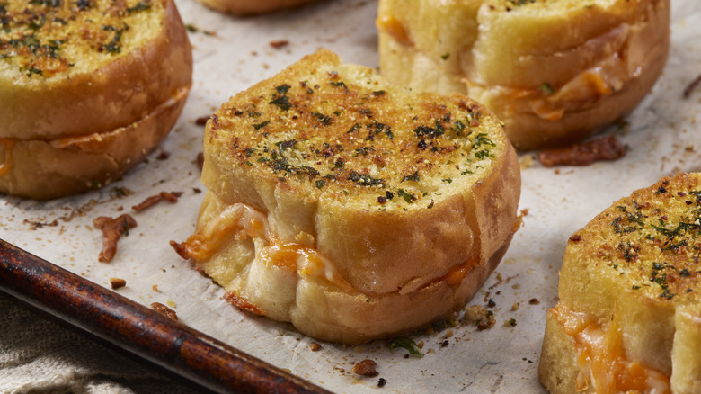 mini garlic breads sitting on a baking tray