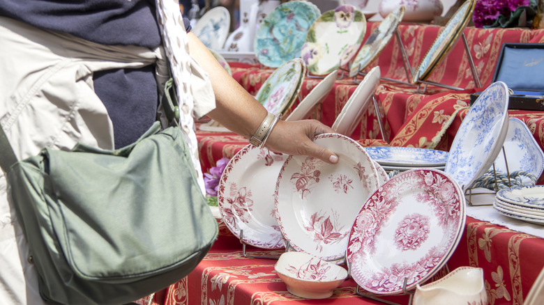 person exploring plates at estate sale