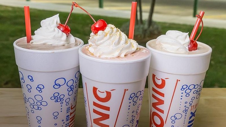 Three milkshakes in to-go cups from Sonic