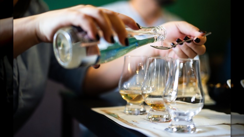 Adding a spoonful of water to whiskey glasses