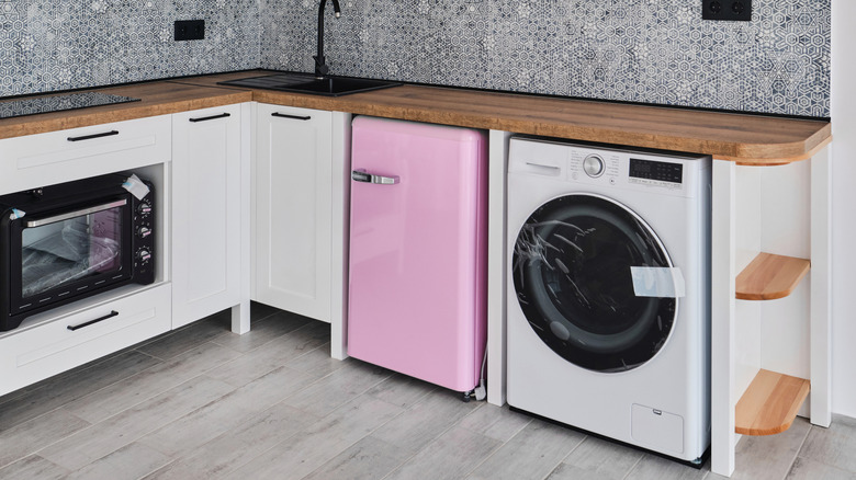 A pink mini fridge installed in the kitchen