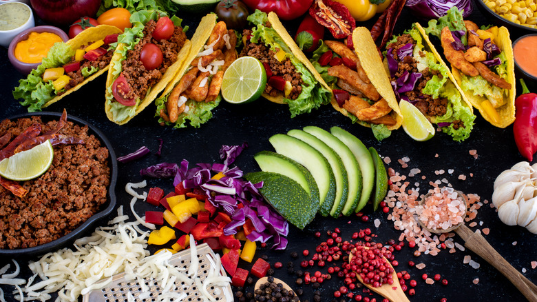 Overhead view of a spread of taditional Mexican cuisine, including tacos, ground beef, and avocado
