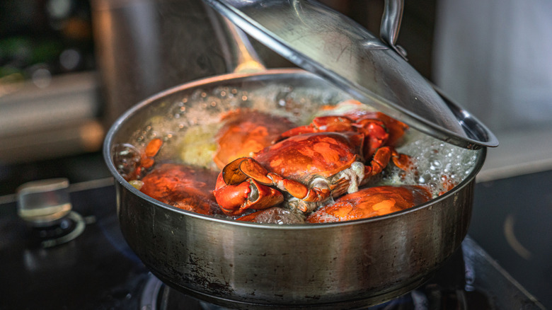 Bright red crabs boil in a pot.