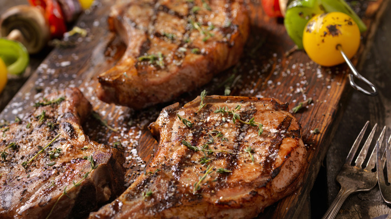 grilled pork chops served with vegetable skewers