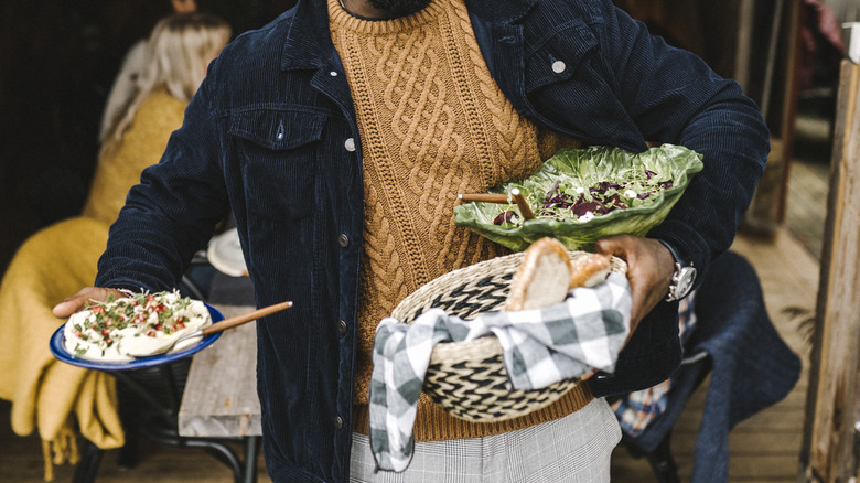 A guest bringing food to a party