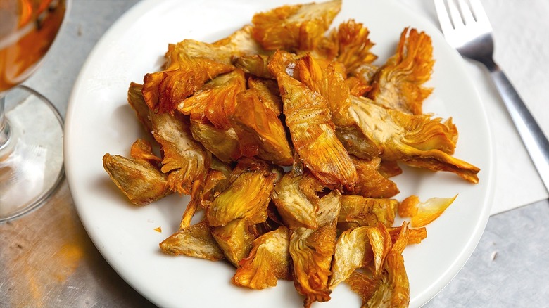 Fried and quartered artichoke hearts on white plate