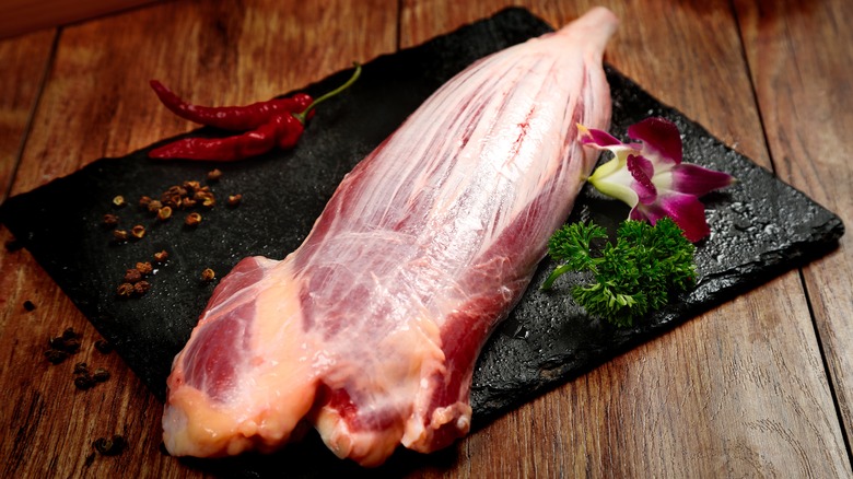 Untrimmed beef tenderloin laying on a piece of slate