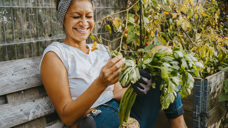 woman sitting in her garden examining produce