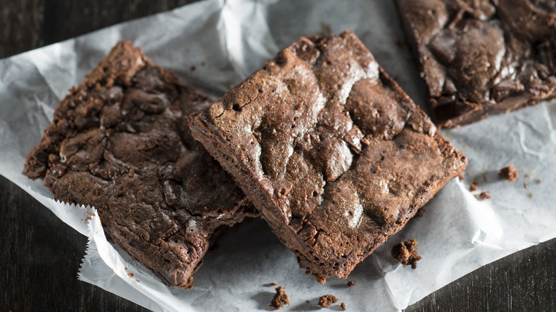 Brownies on a piece of waxed paper.