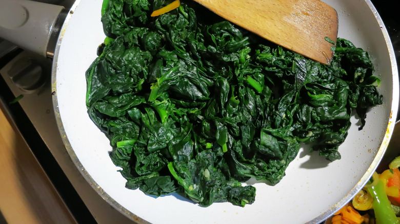 Homemade sauted spinach in a home kitchen on a Gas Stove.