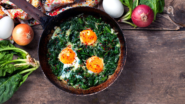 Braised spinach and eggs in a frying pan