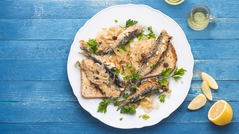 Dish of sardines on toast with wine carafe