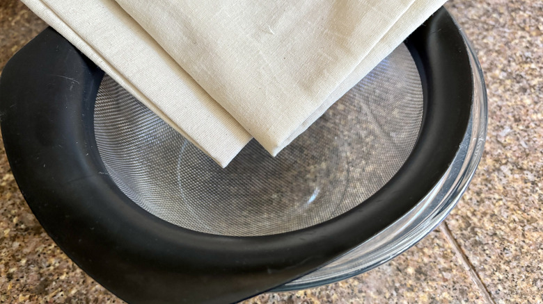 Cheesecloth bundles on top of a strainer