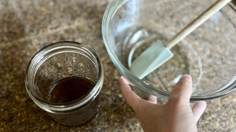 hand holding glass bowl with spatula