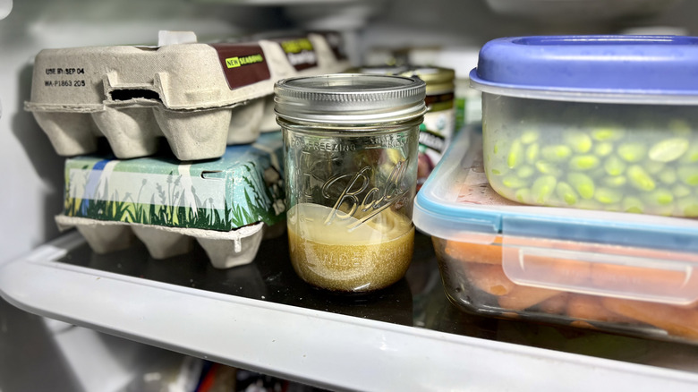 A jar of bacon grease stored in a fridge