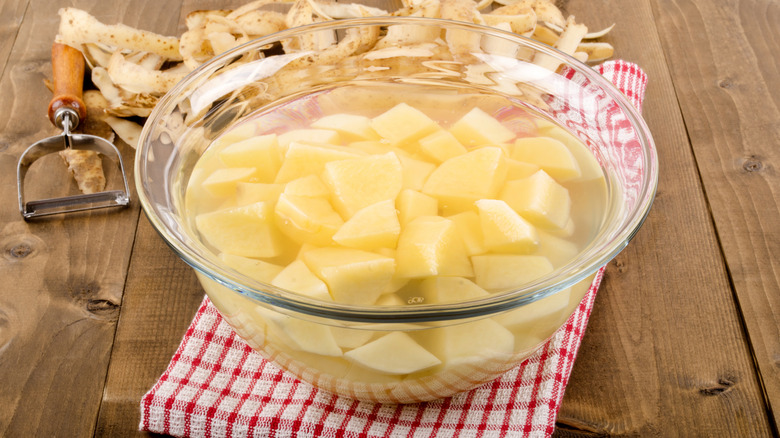 diced potatoes in a glass bowl with water to remove the potato starch