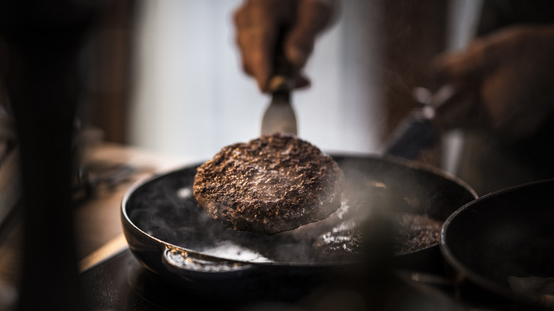 Cooking burger patties in stovetop skillet at home