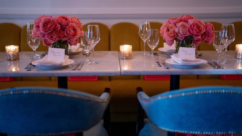 Table set with place cards and vases filled with pink roses