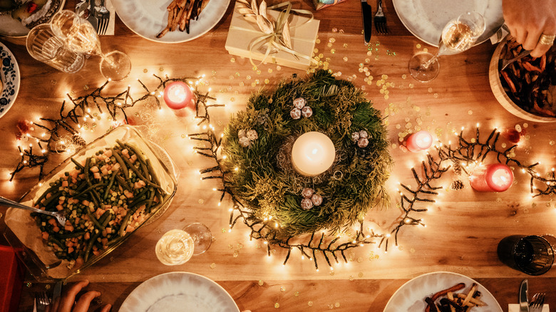 Tablescape with a wreath, twinkle lights, and lit gandles