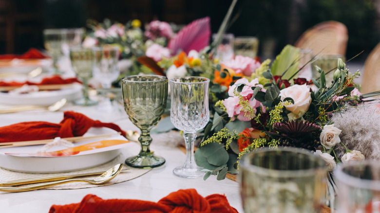 Tablescape with red cloth napkins and low floral centerpieces