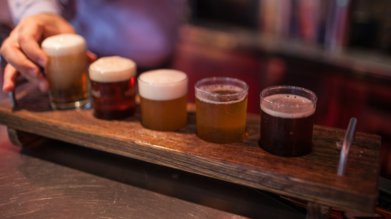 hand places fifth beer in flight on bar