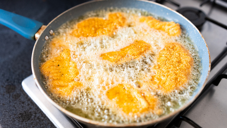 fried fish in hot oil in pan