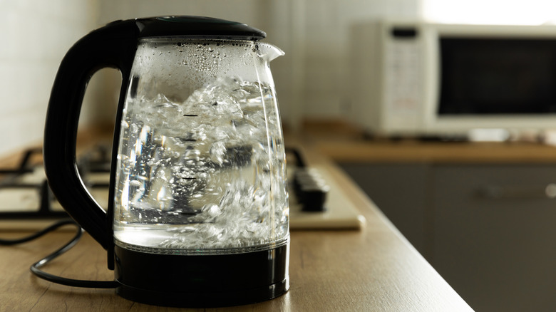 An electric transparent kettle on a kitchen countertop.