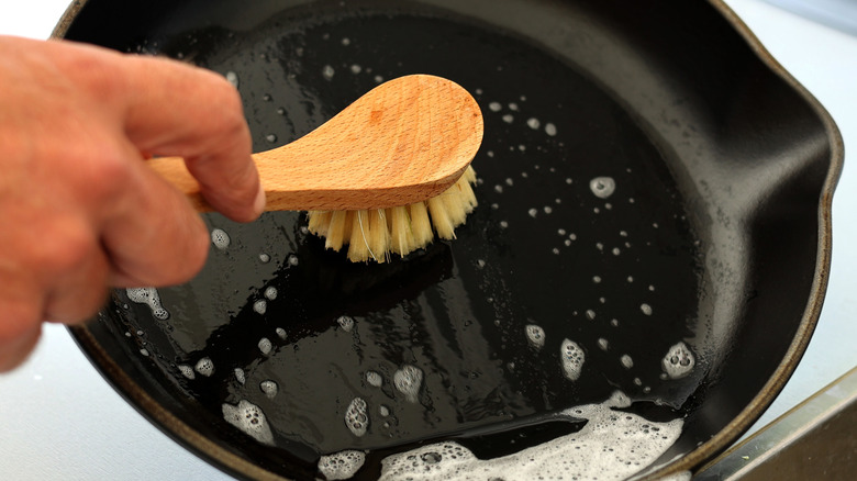 scrubbing a cast iron with soap and water