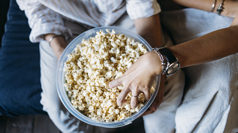 friends sharing a freshly popped bowl of popcorn