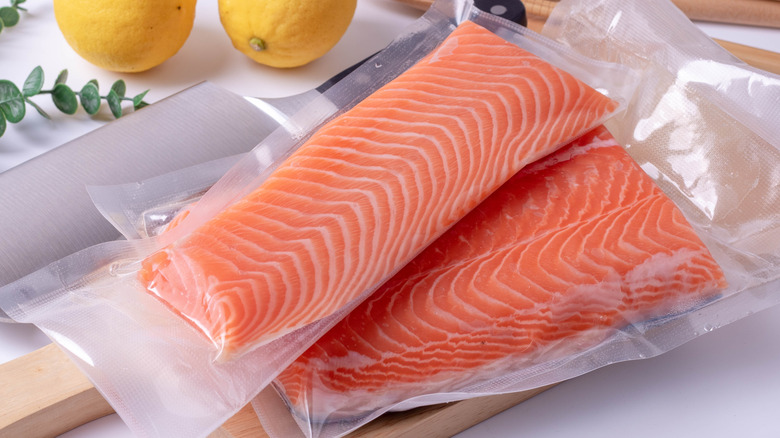 Two fillets of uncooked salmon in plastic packaging
