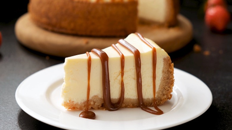 A slice of cheesecake with caramel sauce drizzle