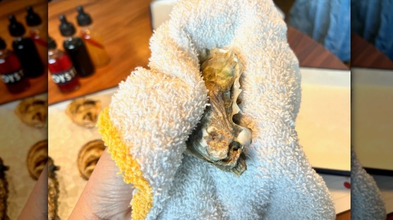 Chef Dom Crisp holding oyster in a kitchen towel
