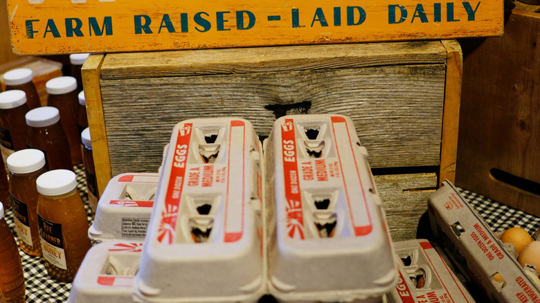 eggs for sale under sign that reads: "fresh eggs, farm raised - laid daily"