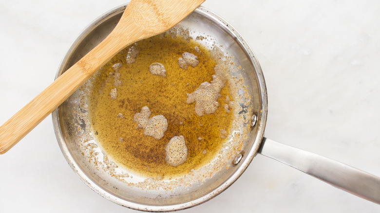 Browned butter in a frying pan with a metal spoon