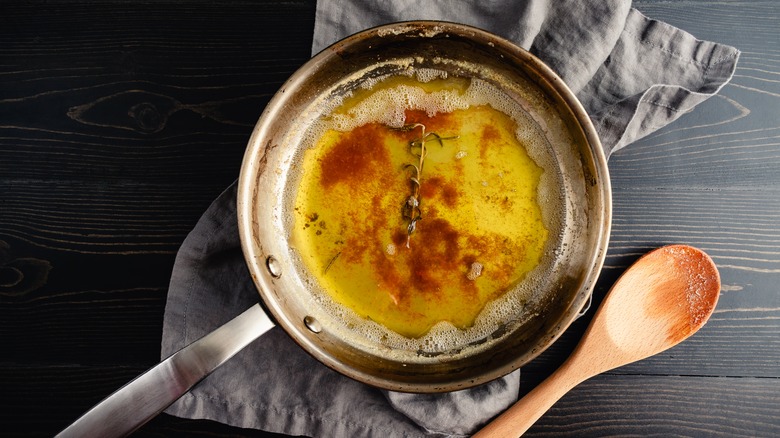 Browned butter in a pan with a sprig of rosemary