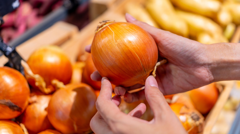 woman shopping for onions in grocery store